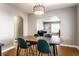 Open-concept dining area with hardwood floors and views of the living room, featuring an ornamental light fixture above at 5428 E 10Th St, Indianapolis, IN 46219