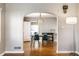 Charming dining room with an open archway to another room, hardwood floors, and modern lighting at 5428 E 10Th St, Indianapolis, IN 46219
