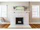 Classic fireplace with decorative sconces, hardwood floors, and bright windows at 5428 E 10Th St, Indianapolis, IN 46219