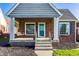 Welcoming front porch with swing, turquoise door, and beautiful landscaping at 5428 E 10Th St, Indianapolis, IN 46219