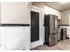 Updated kitchen with stainless steel appliances and white cabinets, with a black door leading to an unknown room at 5428 E 10Th St, Indianapolis, IN 46219