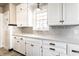 Updated Kitchen featuring white cabinets, a grey backsplash, updated countertops and an updated sink beneath a window at 5428 E 10Th St, Indianapolis, IN 46219