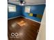 Bedroom with blue walls, hardwood floors, a ceiling fan, and two windows at 5802 Bertha St, Indianapolis, IN 46241