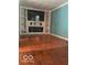 Bright living area featuring a stone fireplace, built-in shelving, and hardwood floors at 5802 Bertha St, Indianapolis, IN 46241