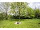 Backyard featuring a fire pit with a stone border, and a lush green lawn at 5824 W Commonview Dr, McCordsville, IN 46055