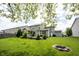 Spacious backyard with lush green lawn, fire pit, landscaping, and a charming pergola-covered patio at 5824 W Commonview Dr, McCordsville, IN 46055