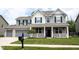 Charming two-story home featuring a welcoming front porch, well-manicured lawn, and a two-car garage at 5824 W Commonview Dr, McCordsville, IN 46055