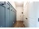 Hallway featuring blue board and batten accent wall and white doors with black hardware at 5824 W Commonview Dr, McCordsville, IN 46055