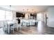 Bright, open kitchen with dark cabinetry, white island seating, and modern pendant lighting fixtures at 5824 W Commonview Dr, McCordsville, IN 46055