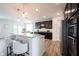 Modern kitchen featuring an island with bar stool seating, granite countertops, and dark wood cabinetry at 5824 W Commonview Dr, McCordsville, IN 46055