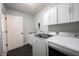 Functional laundry room with sleek appliances, upper cabinets, and striking black tile floor at 5824 W Commonview Dr, McCordsville, IN 46055