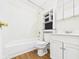Bathroom featuring tub with shower, toilet, wood-look floor and storage cabinet above sink at 602 W 34Th St, Anderson, IN 46013