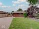 Exterior view of home with brick and paved driveway, showcasing a neatly maintained lawn and garden, and fence at 6069 E 15Th St, Indianapolis, IN 46219