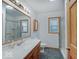 Bright bathroom features a large mirror, single vanity, and shower with glass door at 6069 E 15Th St, Indianapolis, IN 46219