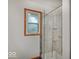 Tiled shower featuring clear glass door and chrome showerhead fixture at 6069 E 15Th St, Indianapolis, IN 46219