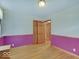 Bedroom with hardwood floors, pink color-blocked walls, and natural light at 6069 E 15Th St, Indianapolis, IN 46219