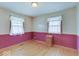 Bedroom with hardwood floors, and pink color-blocked walls at 6069 E 15Th St, Indianapolis, IN 46219