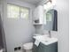 A bright bathroom offers an oval mirror, a single sink vanity, and stylish fixtures at 6143 E 43Rd St, Indianapolis, IN 46226