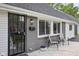 Detailed view of the home entrance, showcasing a secure door and stylish seating on the front porch at 6143 E 43Rd St, Indianapolis, IN 46226