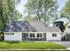 Charming Cape Cod-style home with a manicured lawn and a cozy front porch seating area at 6143 E 43Rd St, Indianapolis, IN 46226