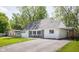 Charming Cape Cod-style home with carport, featuring a manicured lawn and a cozy front porch seating area at 6143 E 43Rd St, Indianapolis, IN 46226