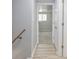 Hallway with light wood floors leading to carpeted bedroom at 6143 E 43Rd St, Indianapolis, IN 46226