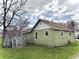 Side view of a green one-story house with a wooden fence and trees at 620 W Central Ave, Greensburg, IN 47240