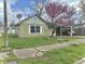 Charming one-story home with a vibrant redbud tree in the front yard at 620 W Central Ave, Greensburg, IN 47240