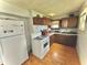 Compact kitchen featuring wood cabinets, white appliances, and wood-look flooring at 620 W Central Ave, Greensburg, IN 47240