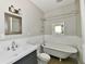 Charming bathroom with vintage-style tub, updated vanity, and decorative mirror at 631 Prospect St, Indianapolis, IN 46203