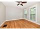 Empty bedroom featuring hardwood floors, neutral paint, large windows, and a ceiling fan at 631 Prospect St, Indianapolis, IN 46203