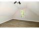 Bright bedroom with angled walls, hardwood floors, neutral paint, a ceiling fan, and window offering natural light at 631 Prospect St, Indianapolis, IN 46203