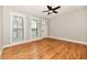 Empty bedroom with hardwood floors, neutral paint, large windows, a ceiling fan, and white trim at 631 Prospect St, Indianapolis, IN 46203