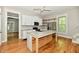 Open kitchen with white cabinets, stainless appliances, center island, and hardwood floors throughout the home at 631 Prospect St, Indianapolis, IN 46203
