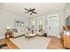 Staged living room with neutral furniture, hardwood floors, large windows, and ceiling fan at 631 Prospect St, Indianapolis, IN 46203