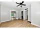 Open living room featuring wood-look floors, a ceiling fan, and doorways leading to other rooms at 631 Prospect St, Indianapolis, IN 46203