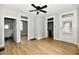 Spacious living room with wood-look floors, ceiling fan, and multiple doorways to other rooms at 631 Prospect St, Indianapolis, IN 46203