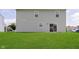 Large backyard featuring a well-manicured lawn and light green siding on the home at 6410 Avacado Dr, Indianapolis, IN 46217