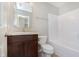 Bathroom showcasing a wooden vanity, toilet, and a tub with a shower at 6410 Avacado Dr, Indianapolis, IN 46217