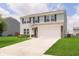 Inviting two-story home featuring blue shutters, light siding, and an attached two-car garage at 6410 Avacado Dr, Indianapolis, IN 46217