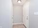 Neutral hallway featuring tiled floor, white doors, and light switch at 6410 Avacado Dr, Indianapolis, IN 46217
