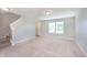 Bright living room with neutral carpet, staircase, white trim, and large window at 6410 Avacado Dr, Indianapolis, IN 46217