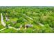 This aerial showcases lush, mature trees surrounding a beautiful home with a pond at 6462 Wings Ct, Brownsburg, IN 46112