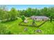 An aerial view features a home surrounded by mature trees and a private pond at 6462 Wings Ct, Brownsburg, IN 46112