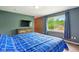 Calm bedroom with a view, featuring a blue comforter, TV, and wooden dresser at 6462 Wings Ct, Brownsburg, IN 46112