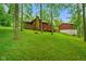 A charming home with a stone chimney and a lovely deck, nestled on a lush green lawn with many trees at 6794 E Ann St, Camby, IN 46113