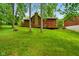 View of home's backyard featuring lush lawn, a stone chimney, large wooden deck, and mature trees at 6794 E Ann St, Camby, IN 46113