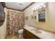 Well-lit bathroom features a vanity, toilet, and floral shower curtain at 6794 E Ann St, Camby, IN 46113