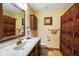 Well-lit bathroom features a vanity with marble countertop, decorative wall hangings, and patterned shower curtain at 6794 E Ann St, Camby, IN 46113