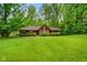 Inviting single-story home featuring a well-manicured lawn and mature trees surrounding the property at 6794 E Ann St, Camby, IN 46113